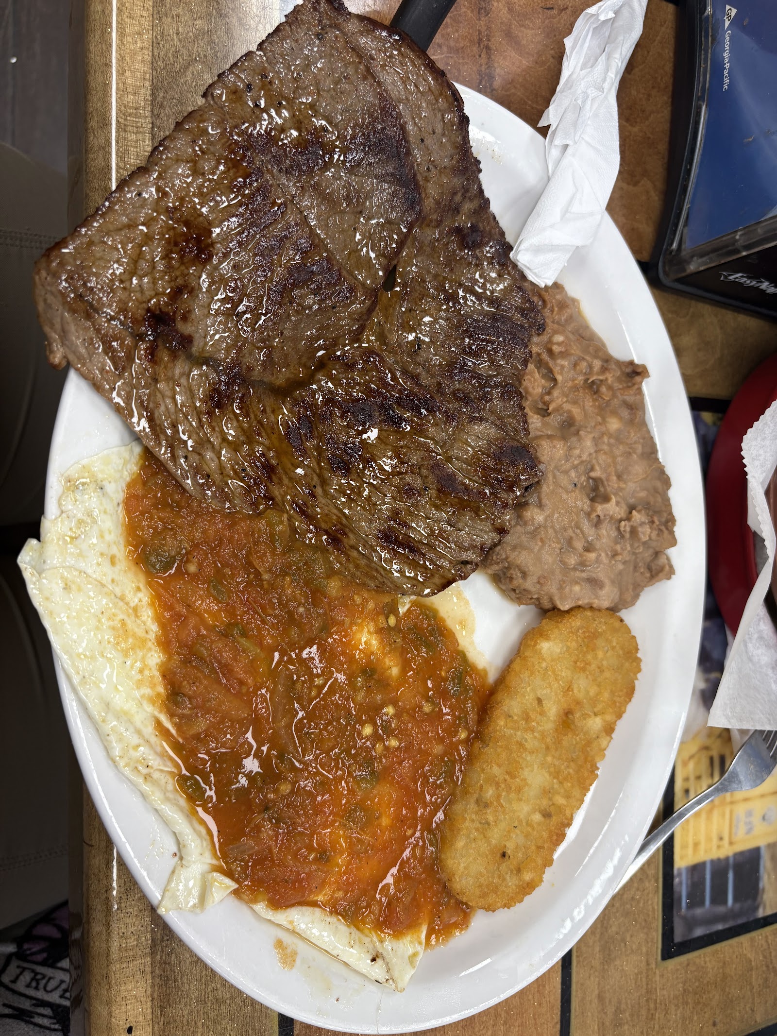 Carne asada breakfast plate with eggs, salsa, beans and a hash brown